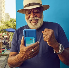 Homem usando chapéu e sorrindo com o celular na mão