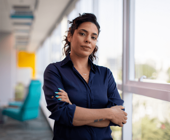 Mulher de braços cruzados séria em escritório