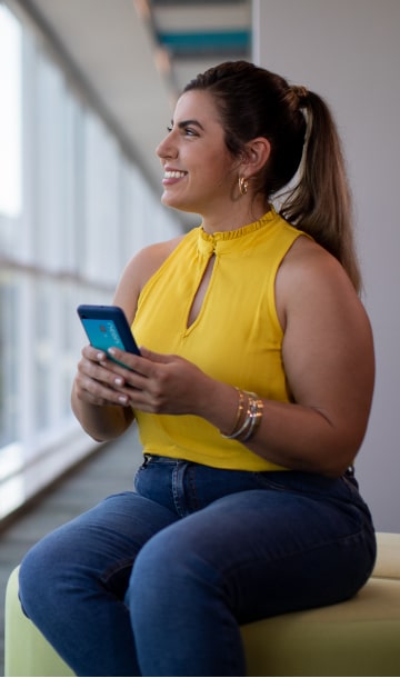 Mulher sorrindo olhando para o lado em escritório