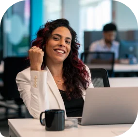 Mulher em escritório sorrindo em frente a computador