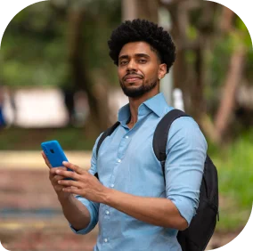 Homem de mochila segurando celular nas mãos