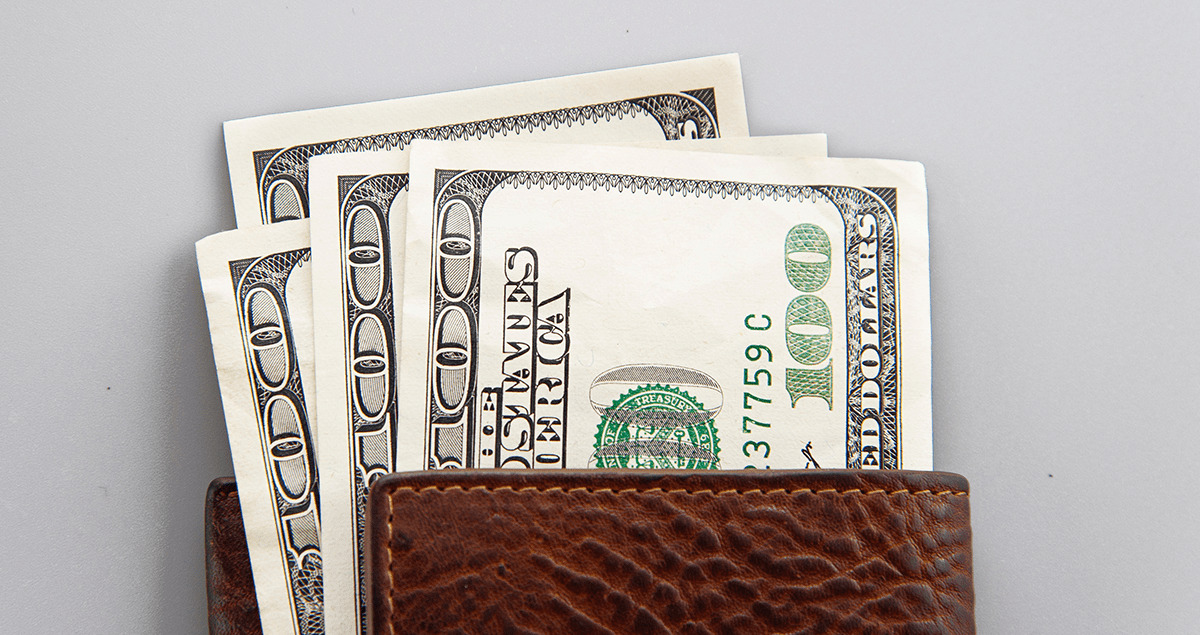 Cédulas de dólar saindo da carteira