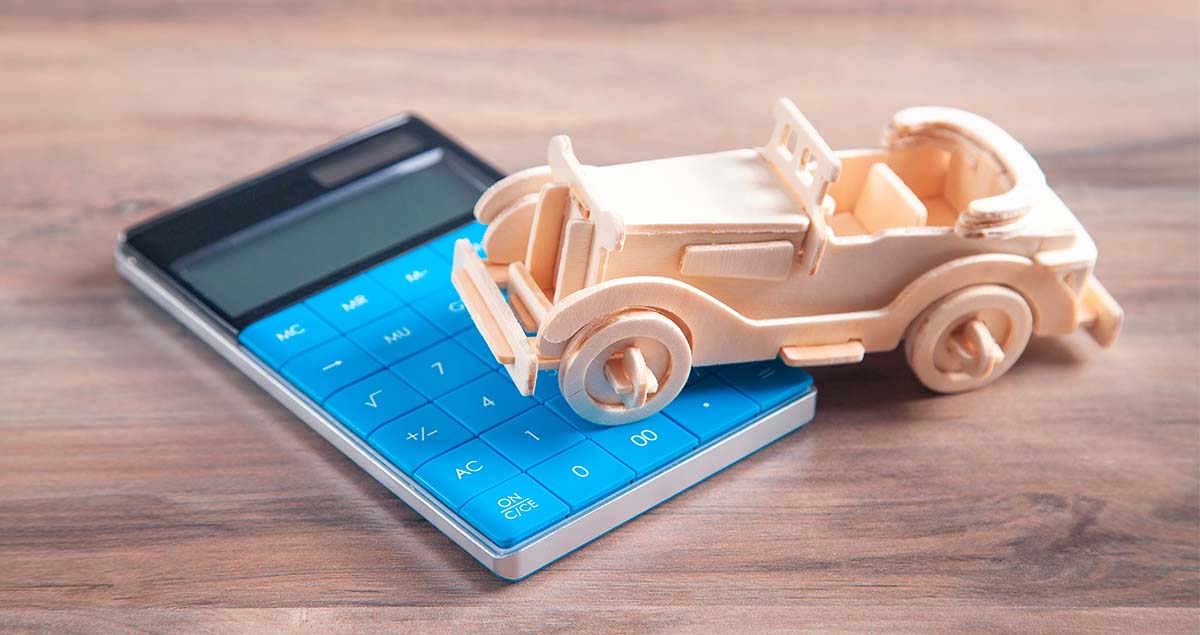 Miniatura de carro antigo sobre calculadora