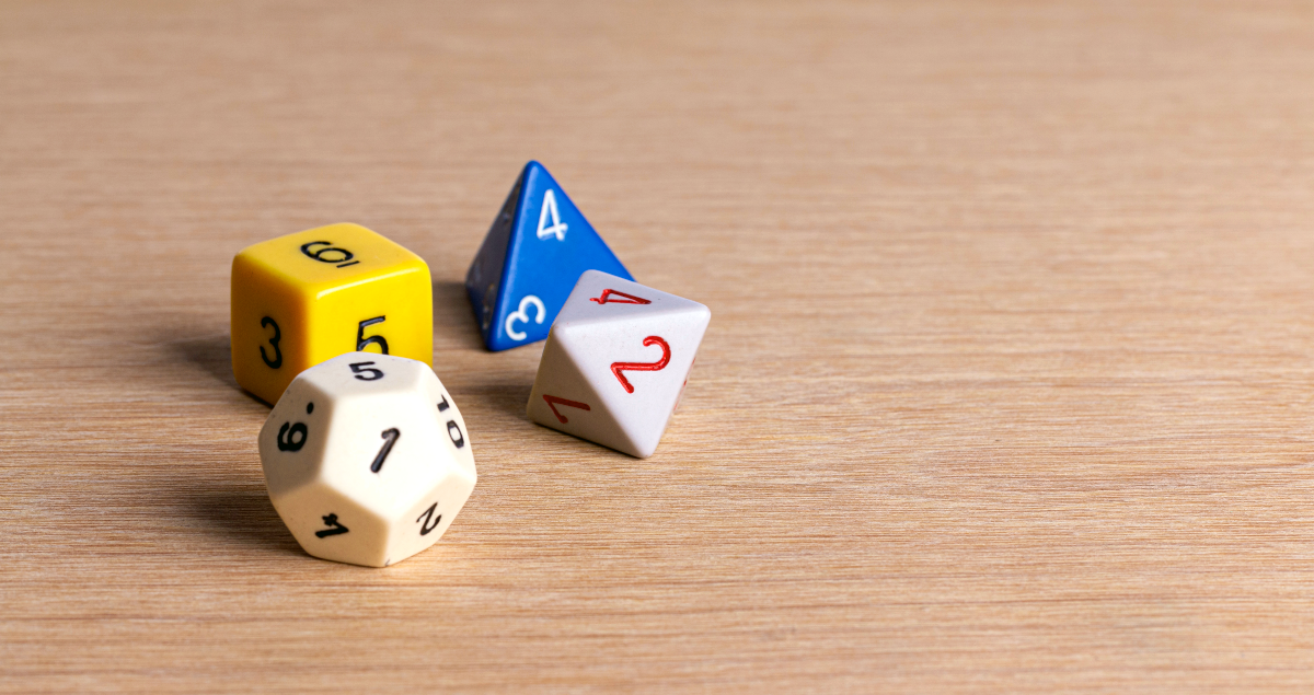Diferentes tipos de dados de jogos de tabuleiro em cima de mesa de madeira