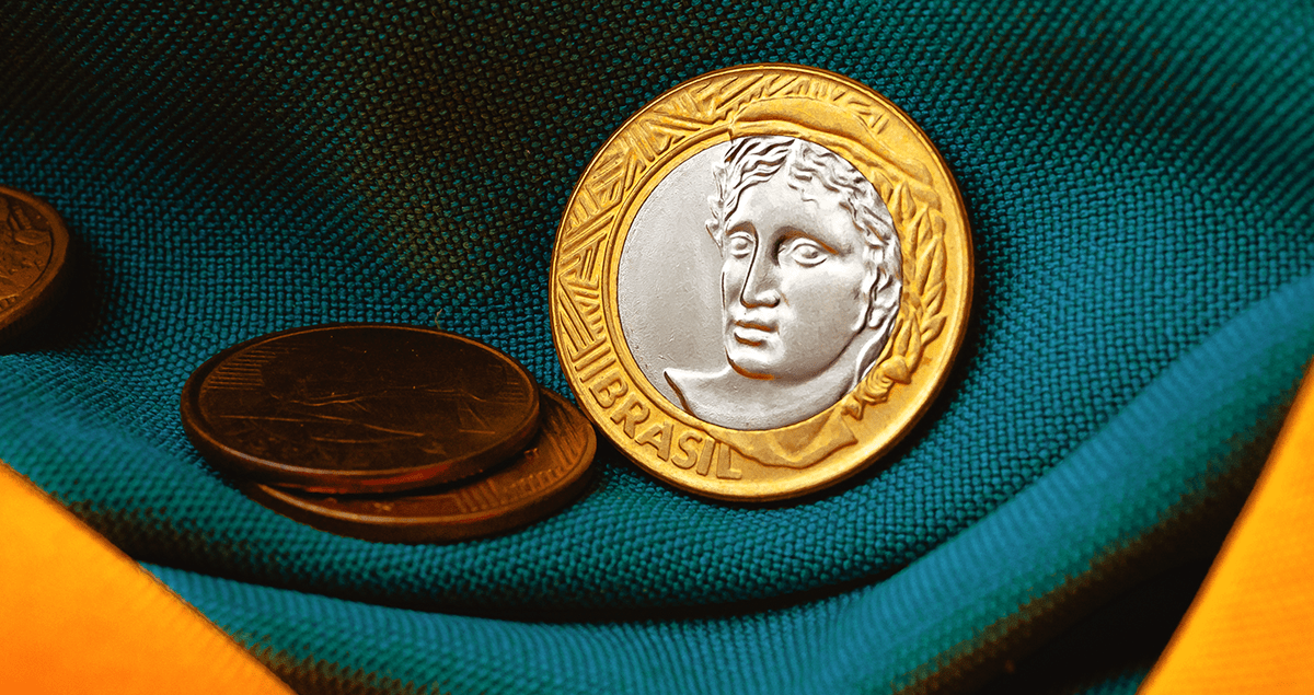 Moedas em cima de bandeira do Brasil