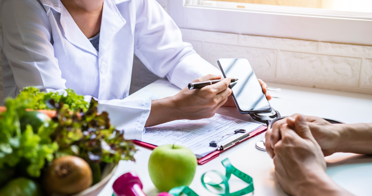 Nutricionista mostrando algo em celular para paciente