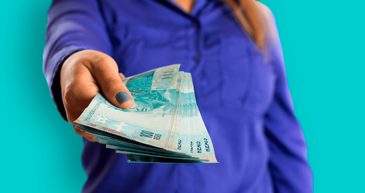 Mulher segurando cédulas de cem reais