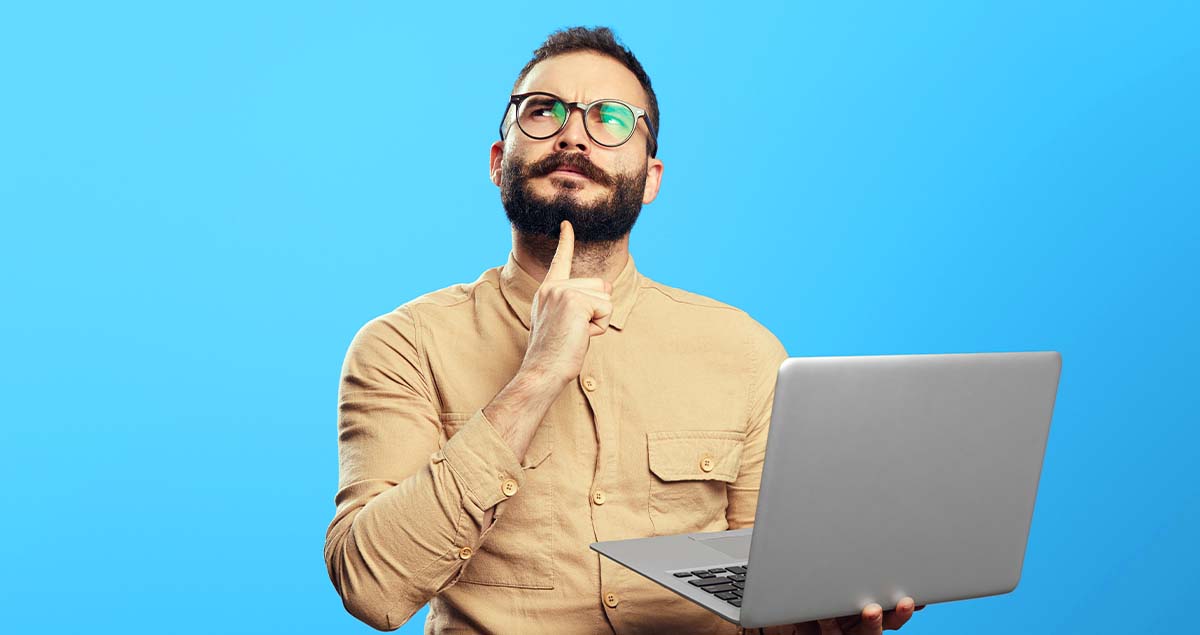 Homem pensativo segurando computador na mão