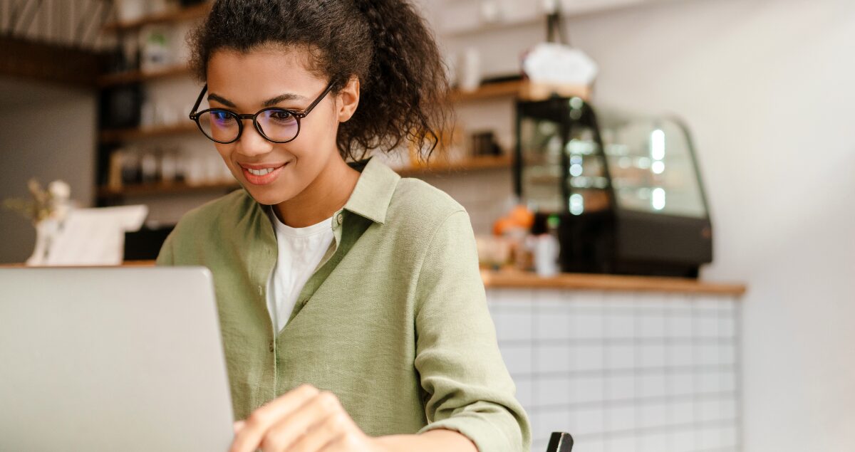 Mulher de óculos escrevendo em computador