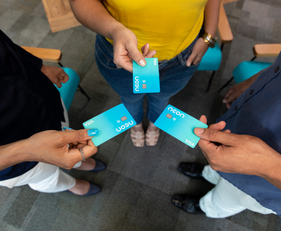 Três pessoas em círculo, cada uma segurando um cartão de crédito Neon na mão