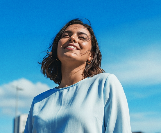 Mulher sorrindo, olhando para cima com luz iluminando o rosto