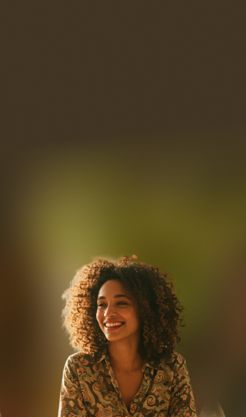 Grupo de pessoas sorrindo e conversando sentados ao redor de uma mesa