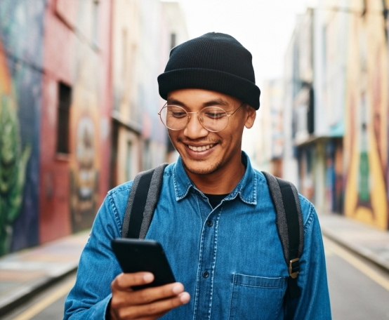 Homem na rua usando o celular