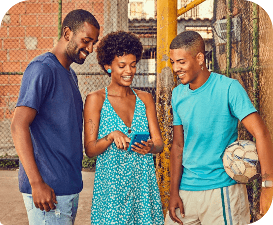 Três pessoas sorrindo olhando para um celular