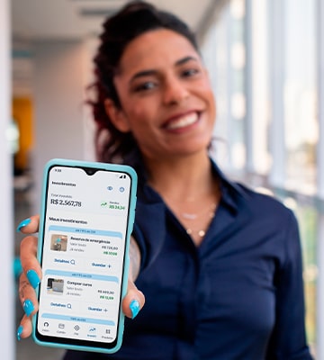 Mulher sorrindo mostrando tela de celular com investimentos no aplicativo Neon
    